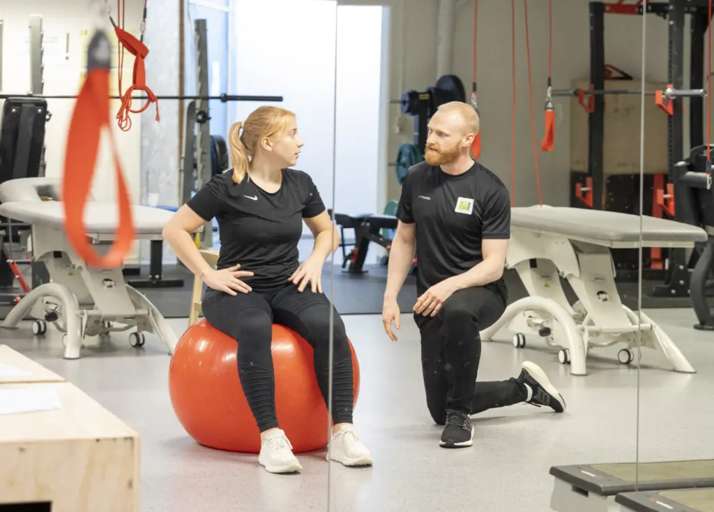 Pasient på ball får veiledning fra fysioterapeut
Foto: Solfure Foto